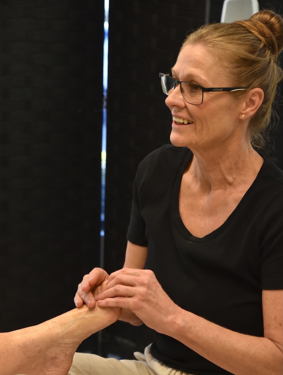 Lynda giving a hand massage to a client